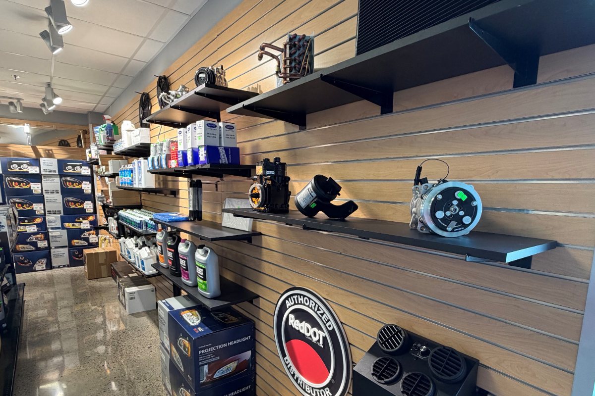 A/C compressors, Red Dot parts, refrigerant, and flush chemicals on the showroom wall